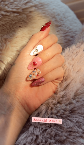 Selena Gomez's hand wearing jeweled icon nail art